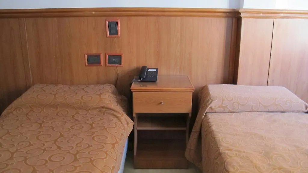 Habitación single con cama individual, mesa de luz y teléfono